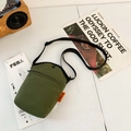 Olive green canvas mini crossbody phone bag with adjustable black strap and brand tag - Green
