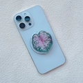 Macro view of a heart-shaped caladium leaf phone grip on a light blue smartphone - Caladium Pink Green White Variegated Style (6)