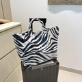 Stylish large capacity zebra print tote bag placed on a grey suitcase for travel - Zebra Print