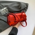Borsa baguette in pelle verniciata rosso lucido con dettagli argento su fondo grigio - Rosso