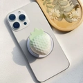 Dettaglio macro del supporto per telefono a fragola con texture sfumata verde opaca - Supporto Magnetico / Fragola Neve Pallida