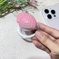 Detail showing a pink strawberry MagSafe phone grip with textured resin design held in hand - Magnetic Stand / Glossy Marshmallow Strawberry