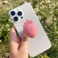 Close-up of pink 3D strawberry phone grip on a white smartphone held in a hand - Glossy Marshmallow Strawberry
