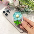 Macro di un supporto per telefono a forma di fiore 3D blu su uno smartphone viola - Supporto Magnetico / Girasole - Blu