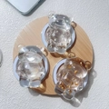 Details von bärenförmigen Harz-Handyhaltern mit Silber- und Goldfolie auf einem Holztablett - Transparenter Zirkonia Bär