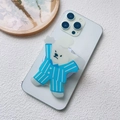 Detail view of a cute cartoon dog acrylic phone grip stand on a white smartphone - Magnetic Stand / Pajama Bear