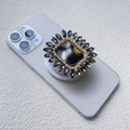 Dettaglio supporto magnetico per cellulare con strass grigio scuro su uno smartphone viola - Stile Airbag Magnetico / Nero
