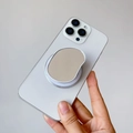 Dettaglio del supporto per telefono ovale beige con specchio su uno smartphone bianco - Supporto Magnetico / Specchio Ovale Bianco