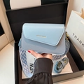 Light blue square crossbody bag with textured strap and flap design in a gift box setup - Blue