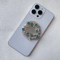 Vista macro di un supporto magnetico per telefono con strass su uno smartphone viola - Supporto Magnetico / Blu