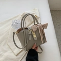 Sac seau gris en cuir grainé avec boucles dorées et décoration foulard en soie chic - Gris