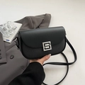 Minimalist black square saddle bag with leather patchwork and silver buckle on a blazer - Black