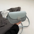 Light blue crossbody saddle bag with a silver geometric buckle and slim leather strap - Blue
