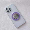 Detail of purple magnetic makeup mirror phone grip attached to white smartphone back - Purple