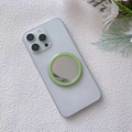Close-up of a light green magnetic makeup mirror attached to a white smartphone - Grass Green