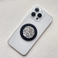 Detail of a round magnetic phone grip featuring silver glitter and a black frame - Magnetic Stand / Silver