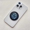 Detail of blue glitter phone grip with star sequence mounted on a white smartphone - Magnetic Stand / Blue