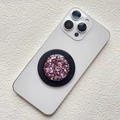 Macro shot of circular magnetic phone socket with pink glitter sequins on black base - Magnetic Stand / Purplish Red