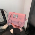 Pink crossbody bag with large silver metallic bow and smooth faux leather finish - Pink