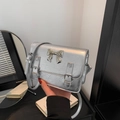 Silver metallic crossbody bag with textured finish and decorative metal bow accent - Silver