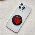 Dettaglio di un supporto per telefono circolare con paillettes rosse su sfondo bianco - Supporto Magnetico / Rosso