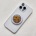 Dettaglio macro del supporto per telefono rotondo con glitter oro e finitura in resina - Supporto Magnetico / Oro