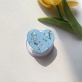 Macro shot of light blue heart-shaped MagSafe phone grip with sparkling glitters and sequins - Magnetic Stand / Blue Silver Foil Glitter Heart