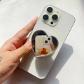 Macro shot of silver heart-shaped mirror phone grip with folding expansion on a white smartphone - Silver Edge Heart Mirror