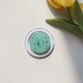 Macro shot of mint green glitter phone grip with star sequins on a white textured base - Magnetic Stand / Green Silver Foil Glitter Round