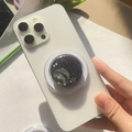 Nahaufnahme eines Handy-Griffs im Planeten-Design mit Glitzersternen auf einem Smartphone - Erde - Schwarze Basis