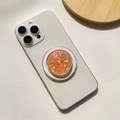 Detailed close-up of a sparkling orange glitter phone grip on a white smartphone case - Magnetic Stand / Orange Large Small Glitter - Round Shape