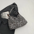 Borsa tote vintage leopardata con dettagli in pelle su sfondo di un blazer grigio - Leopardo Bianco
