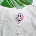 Dettaglio porta badge retrattile con glitter rosa e motivo con faccina sorridente nera - Stile Sorriso Rosa Tondo Quicksand (1)