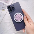Close-up of pink glitter MagSafe phone grip mounted on a purple smartphone held by a model - Magnetic Stand / Bright Pink Glitter