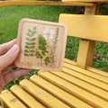 Detail of square wooden coaster with real pressed flowers and leaves in clear resin - Square-9cm
