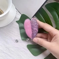 Close-up of acrylic retractable badge reel with heart-shaped monstera leaf design - Pink Princess Leaf