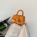 Mini metallic orange crossbody handbag with curved handle and geometric flap design - Orange
