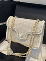 Beige woven crossbody bag with pearl trim and gold chain strap shown on black gift box - Off White / Small