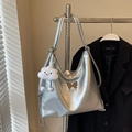 Silver metallic tote bag with bow detail and cloud plush charm hanging on a hanger - Silver