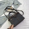 Dettaglio della borsa in denim con bordi in pelle marrone e cuciture in stile vintage - Nero