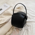 Modern black woven bucket bag with silver chain strap in a stylish lifestyle setting - Black