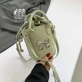 Light green glossy bucket bag with a silver bow and olive green drawstring interior - Green