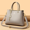 Borsa a mano color talpa in pelle martellata con finiture dorate e pendente a cuore - Grigio