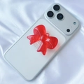 Detail of red translucent 3D bow phone grip on light smartphone over white silk background - Red