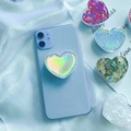 Vue macro d'un support de téléphone cœur holographique avec paillettes et texture coquillage - Cœur Laser