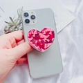 Close-up of a pink glitter heart phone socket grip being held on a white smartphone - Pink Laser