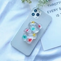 Detail view of a transparent bear phone grip with real colorful dried flowers inside - Three-color Plum Blossom Bear
