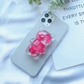 Detail eines transparenten Bären-Handyhalters mit echten rosa Trockenblumen im Inneren - Verlauf Hortensie Bär