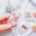 Close-up of cute cartoon bear and cherry Griptok phone stand on a minimalist background - Pink Cow Print and Floral Style(5)