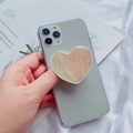 Detalle macro de soporte para móvil en forma de corazón con diseño de mármol veteado - Vieira Blanca Con Borde Blanco